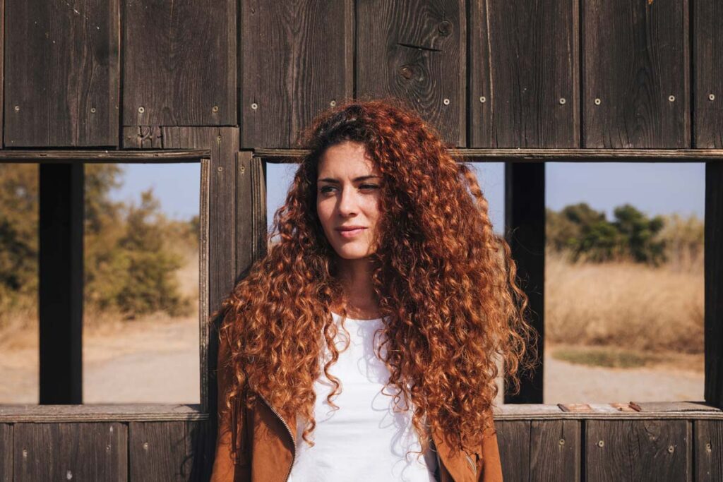 Ragazza con capelli lunghi ricci rossi